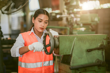 woman worker hard work focus working in heavy metal machine lathe milling factory industry