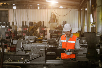 asian engineer male worker work in heavy metal machine lathe milling factory