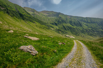 Winding country road in a mountain valley. The Fagaras Mountains, Carpathians, Romania.