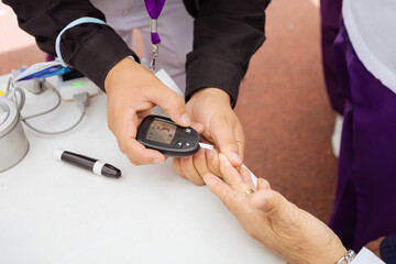 Diabetes checking blood sugar levels. Senior citizen in health campaign