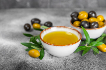 Olive oil in a bottle and gravy boat on the kitchen table. Oil bottle with branches and fruits of olives. Place for text. copy space. vegetable oil and salad dressing.