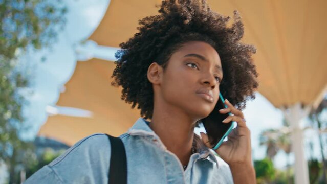 Black haired girl calling cellphone walking street closeup. Teenager talking