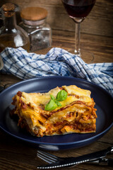 Piece of tasty hot lasagna with red wine.