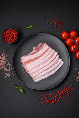 Fresh raw bacon cut into slices with salt, spices and herbs