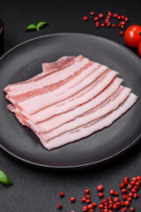 Fresh raw bacon cut into slices with salt, spices and herbs
