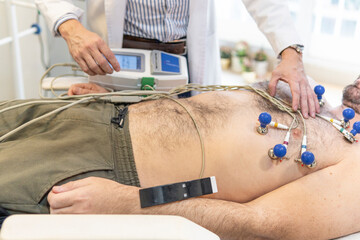 Doctor performing electrocardiogram. Heart exam - obrazy, fototapety, plakaty