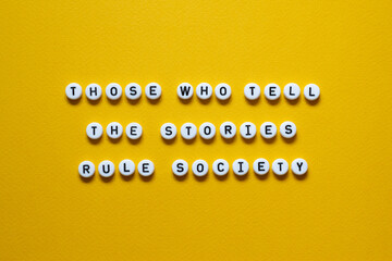 Those who tell the stories rule society - word concept on building blocks, text