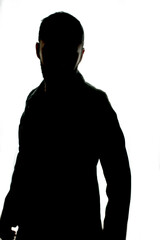 Fototapeta premium silhouette of man in trench coat on bright white background. white background. black silhouette of a person looking back. erect and strong pose of man silhouette. 