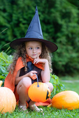 halloween kids. portrait happy girl in witch costume, black hat on scary merry holiday. child with pumpkin, jack o lantern, basket candy sweet, scaring boo. vertical