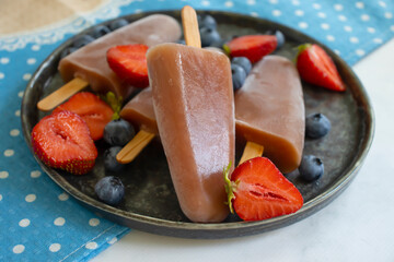 Ice cream with strawberries, blueberries on old background