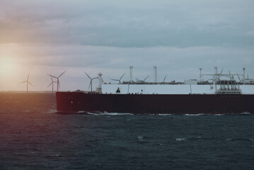 A very large gas carrier is underway with a wind park in the background. LNG tanker. Fully loaded gas tanker. © I am from Mykolayiv
