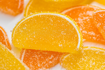 Marmalade lemon slice sprinkled with sugar, on a white background, macro.