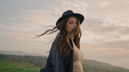 Active girl wanderer walking green valley in stylish hat close up. Pretty model.