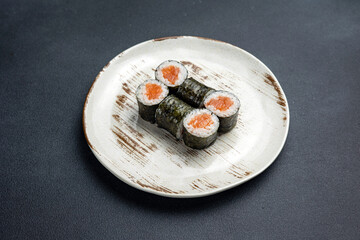 Delicious roll with salmon, Japanese cuisine. Black background. Close up 