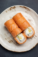 Delicious roll with salmon, Japanese cuisine. Black background. Close up 