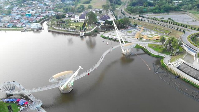 Bird eye view of Darul Hana Bridge over Sungai nearby greenery and houses