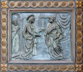 Fototapeta na wymiar NAPLES, ITALY - APRIL 22, 2023: The bronze relief of Visitiation on the gate of church Basilica dell Incoronata Madre del Buon Consiglio from 20. cent.
