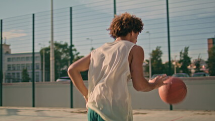Teenager throwing ball basket back view. Modern sportsman playing urban game