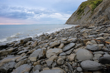 Fototapeta na wymiar Dawn on a rocky beach near Gisborne, New Zealand