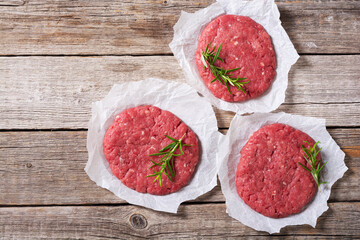 Raw cutlet for beef hamburger on wooden background