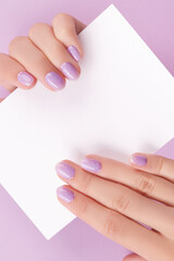 Female hands with trendy manicure holding postcard
