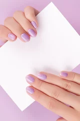 Poster Female hands with trendy manicure holding postcard © Darya Lavinskaya