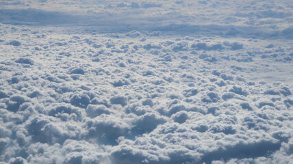 View out of plane window of clouds and sky.
