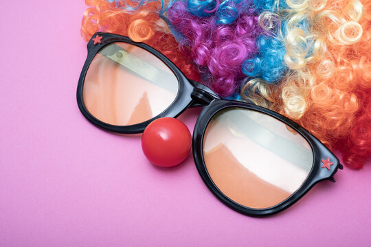 Funny Party concept face formed with glasses lens. Rainbow Clown Wig Set and red clown nose like a face, Fluffy Afro Synthetic Cosplay Anime Fancy Wigs Festive Background