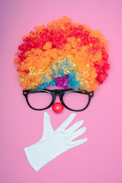 Funny Party concept surprised  face formed with gloves. Rainbow Clown Wig Set with glasses and red clown nose like a face, Fluffy Afro Synthetic Cosplay Anime Fancy Wigs Festive Background