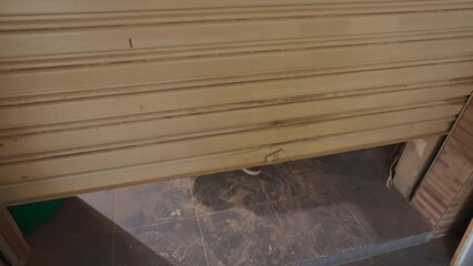 Local carpenter business owner sliding garage door down, closing store front, closed for business concept