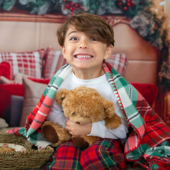 Little boy eating cookies for christmas in a bed and drinking milk and cookies for Santa Claus