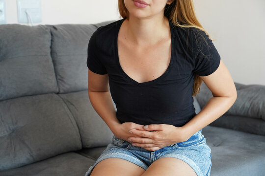 Young woman suffers from pain in the uterus after putting intrauterine contraceptive device. Teenager girl having abdominal pain from period colic during menstrual cycle. Use of the IUD concept.