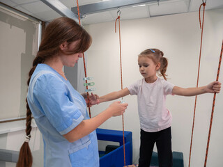 Child girl with physiotherapist playing matching and logic game with clothespins. Great fine motor...