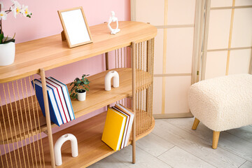 Bookshelf with flowers in interior of living room