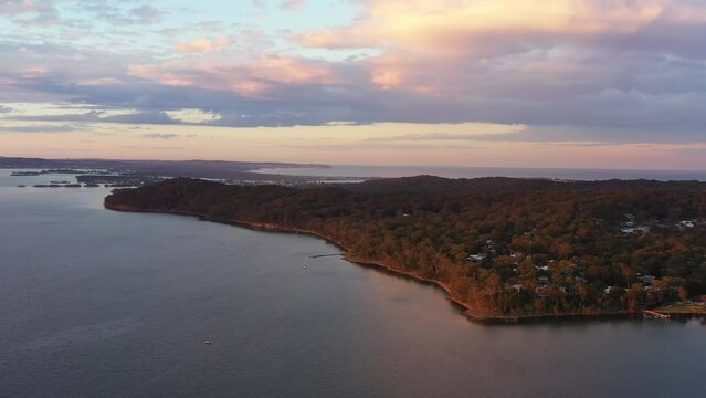 Long aerial panning along lakeshore of Lake Macquarie at Murrays beach 4k.
