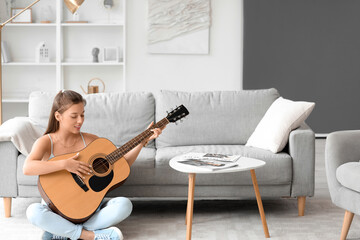 Young woman playing guitar on her day off at home