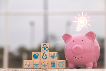 Saving  money.Pig piggy bank with light bulb.The icon finance on wood block. save...