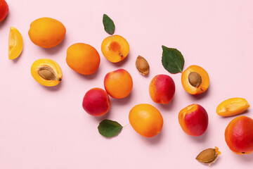 Sweet apricots and leaves on pink background