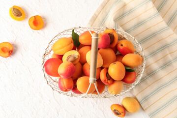 Basket with sweet apricots on white background