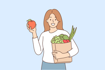Woman buyer bought fruits and vegetables in grocery supermarket and holds paper bag