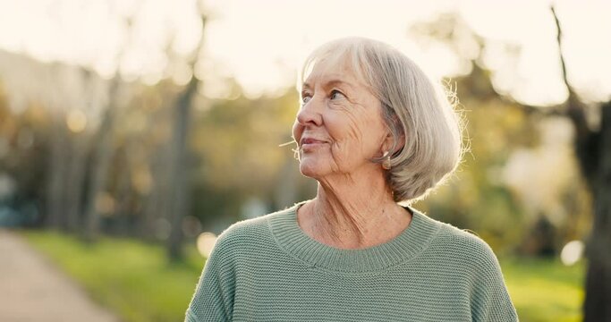 Senior woman, happy and thinking outdoor in a park with happiness, positive mindset and a smile. Face of elderly person in nature, forest or woods for fresh air, health and wellness in retirement
