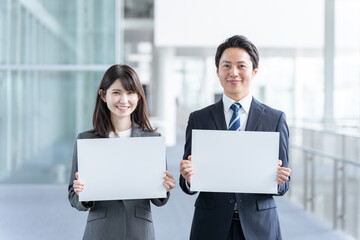 メッセージボードを持つビジネスマン男女