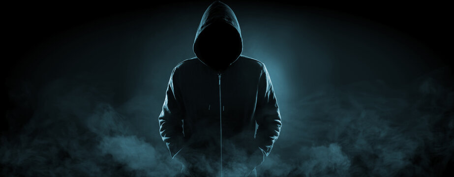 Anonymous man in hood surrounded by smoke on black background. Banner design