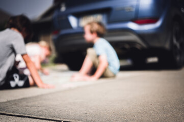 Children sitting on a driveway behind a vehicle in a blind spot out of view of the driver.  © Lost_in_the_Midwest
