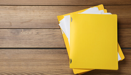 Yellow files with documents on wooden table, top view. Space for text
