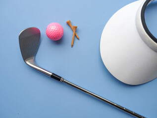 Flat lay of golf equipment on blue background - sport and hobby concept