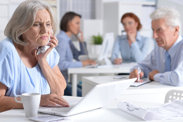 Fototapeta premium sick old businesswoman working in light office