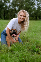 young woman playing with English Bulldog at park