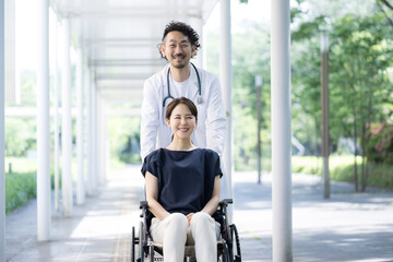 車椅子に乗る女性とドクター　カメラ目線
