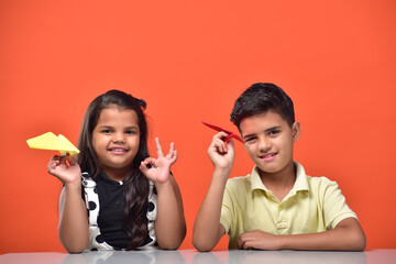 Kid boy and girl holding paper plane 